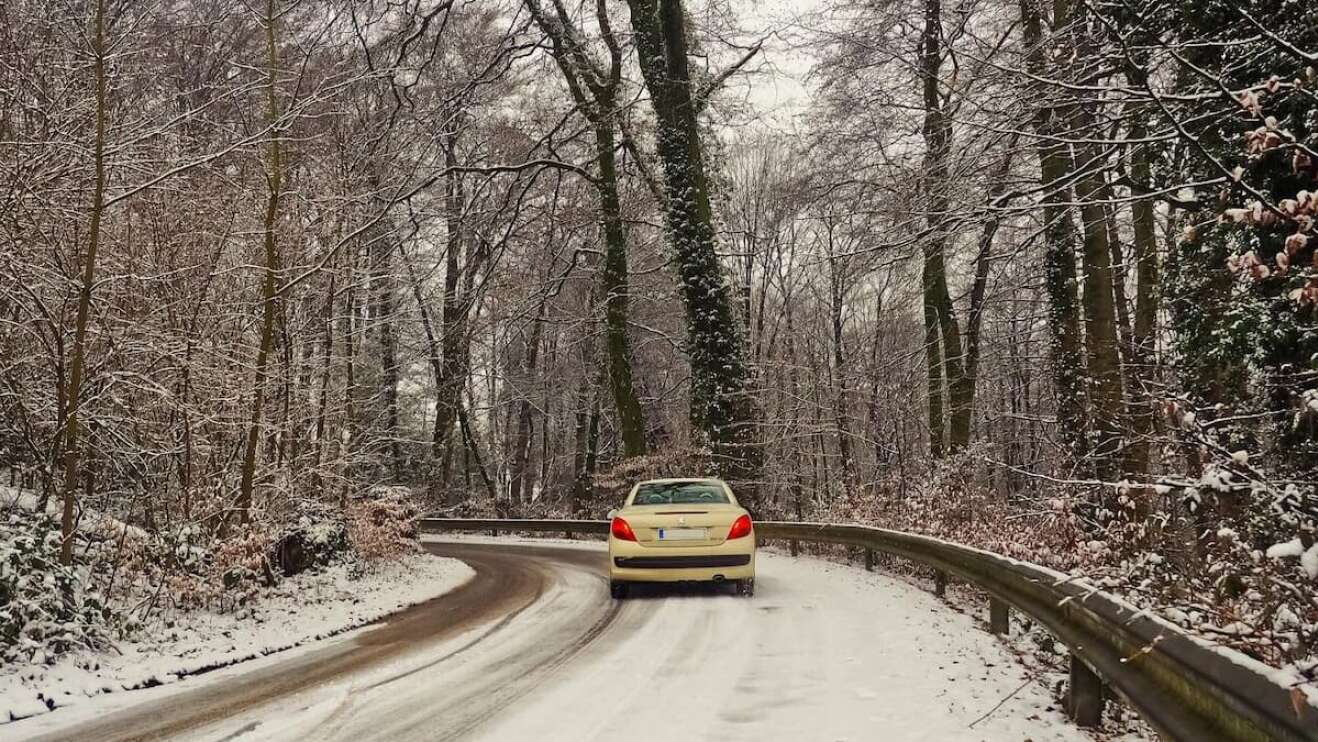 Eine verschneite Straße in einem Wald