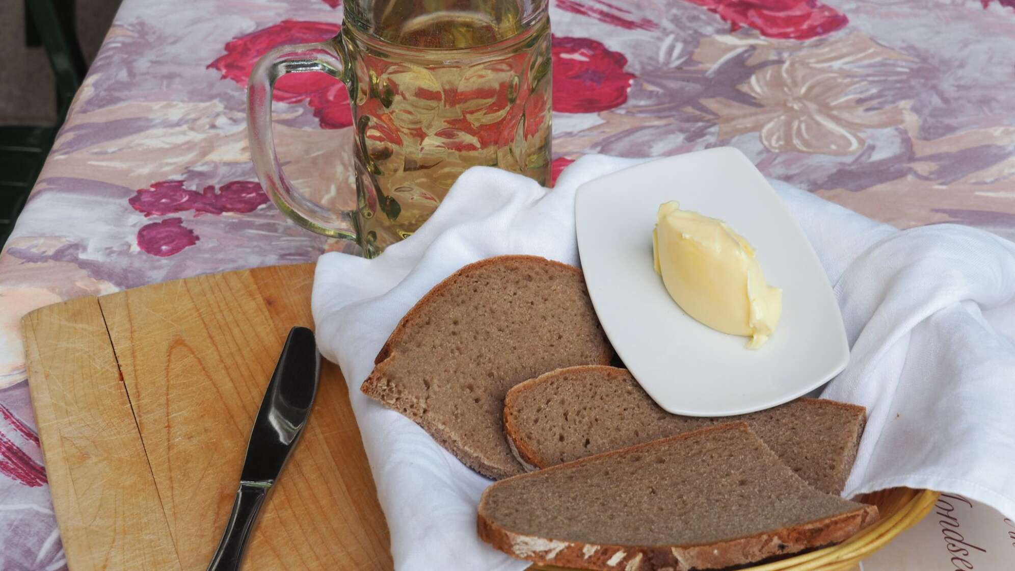 Brot, Butter und Bier stehen auf einem Tisch