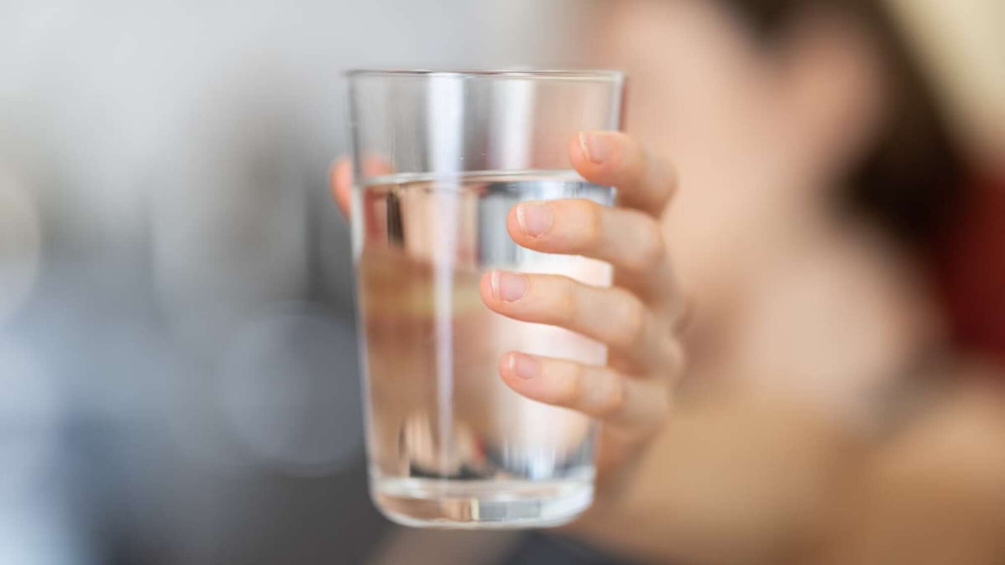 Frau hält Wasserglas