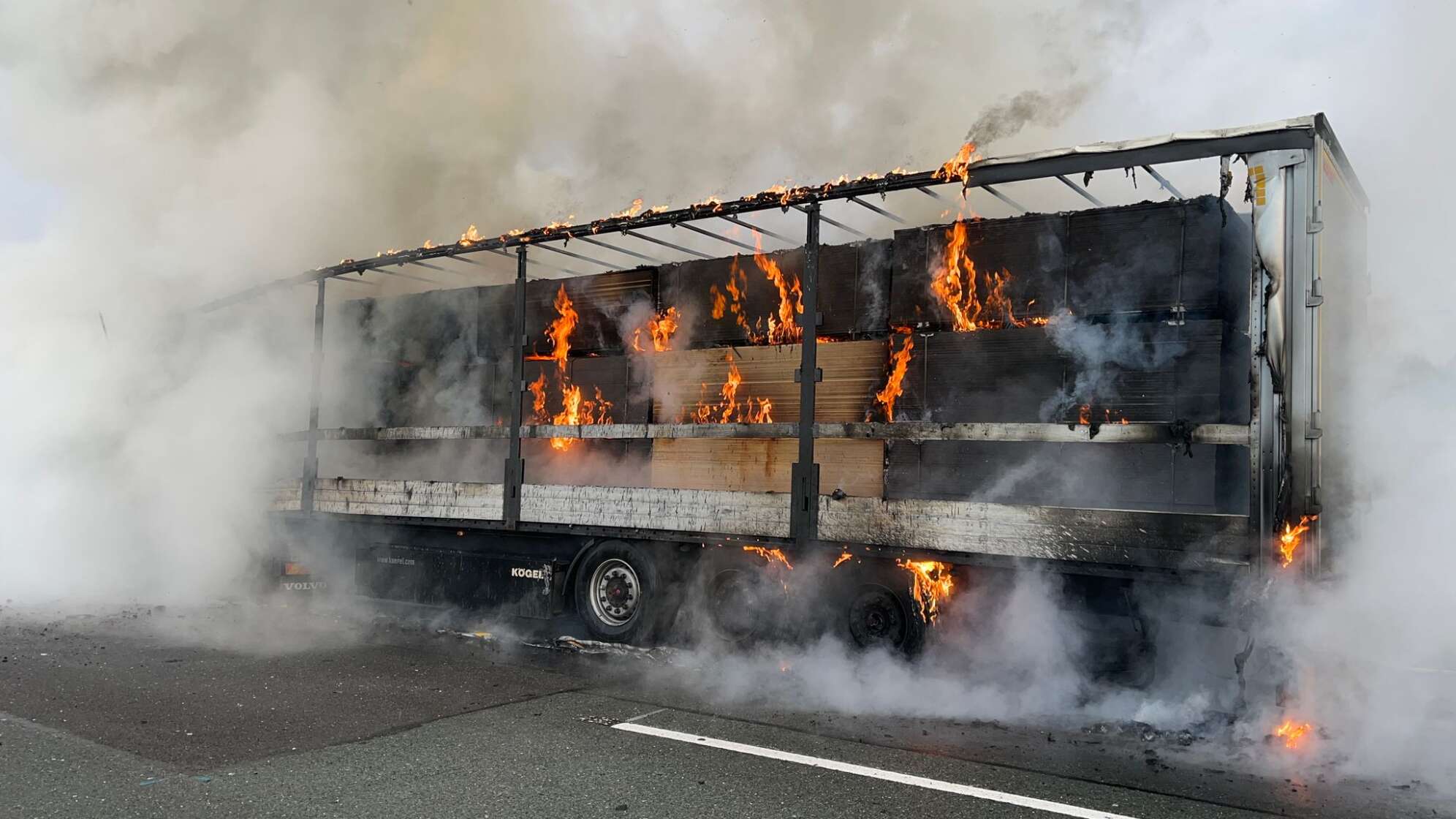 Mit Holz beladener Sattelzug brennt auf Autobahn
