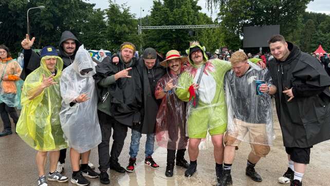 Fans feiern im Regenponcho bei Rock im Park