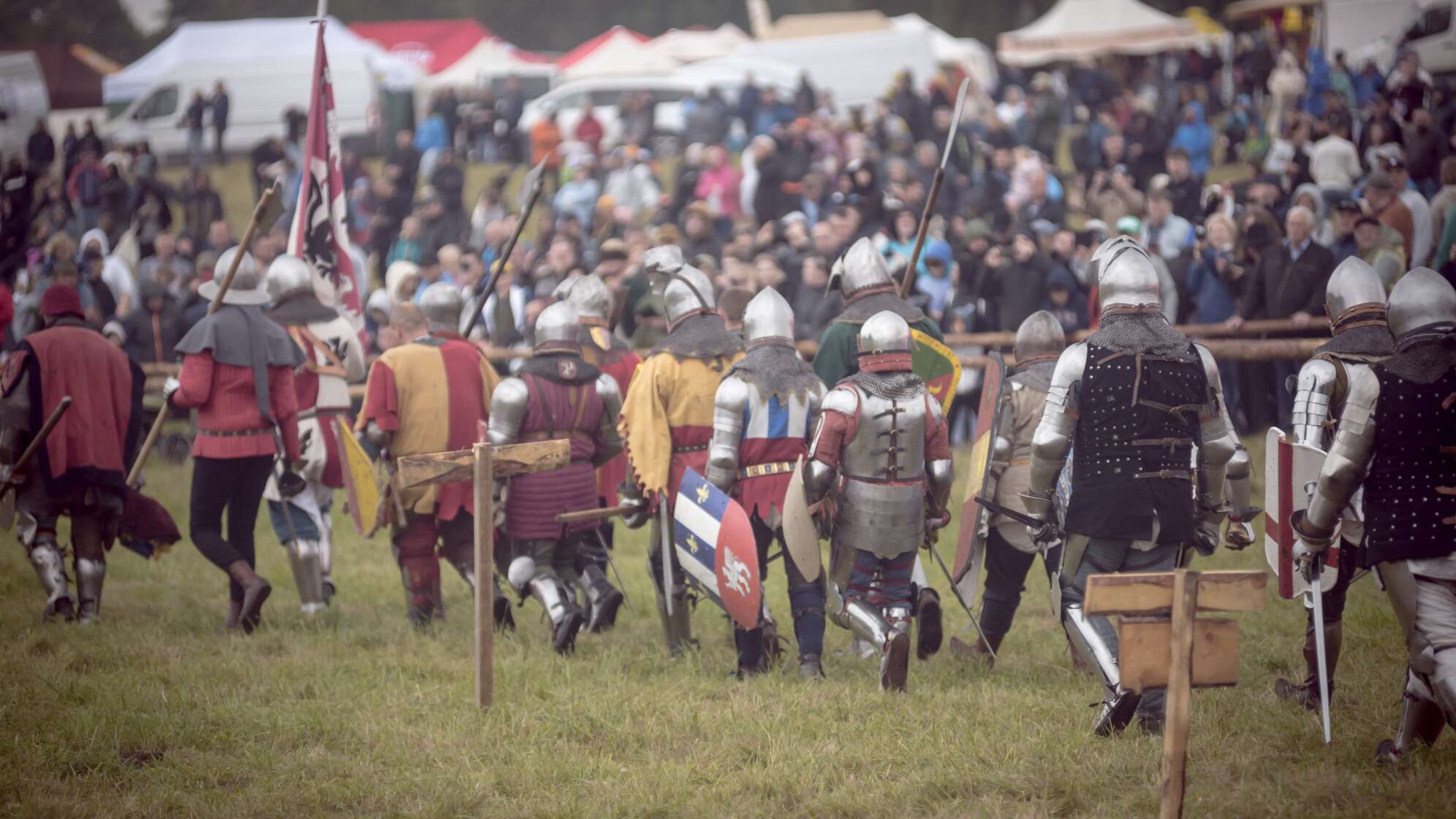 Das Bild zeigt eine mittelalterliche Armee. Die Personen im Heer tragen Ritterrüstungen, Schwerter, Schilde.