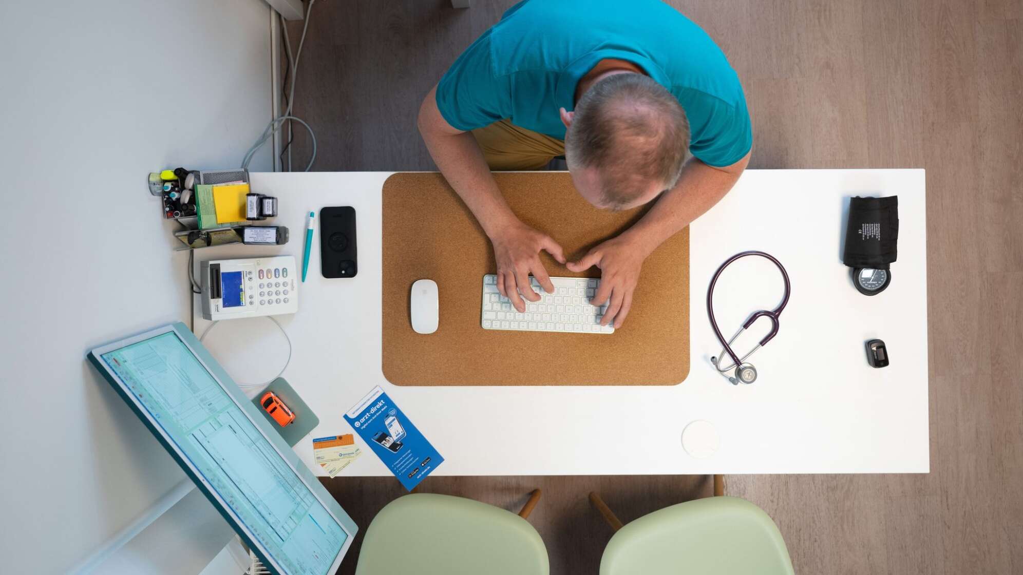 Ein Hausarzt sitzt in einem Sprechzimmer