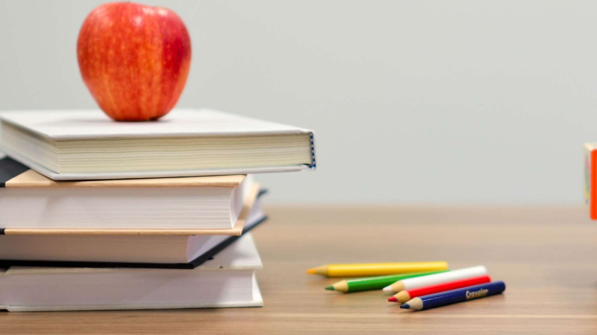 Tisch mit Büchern und Apfel