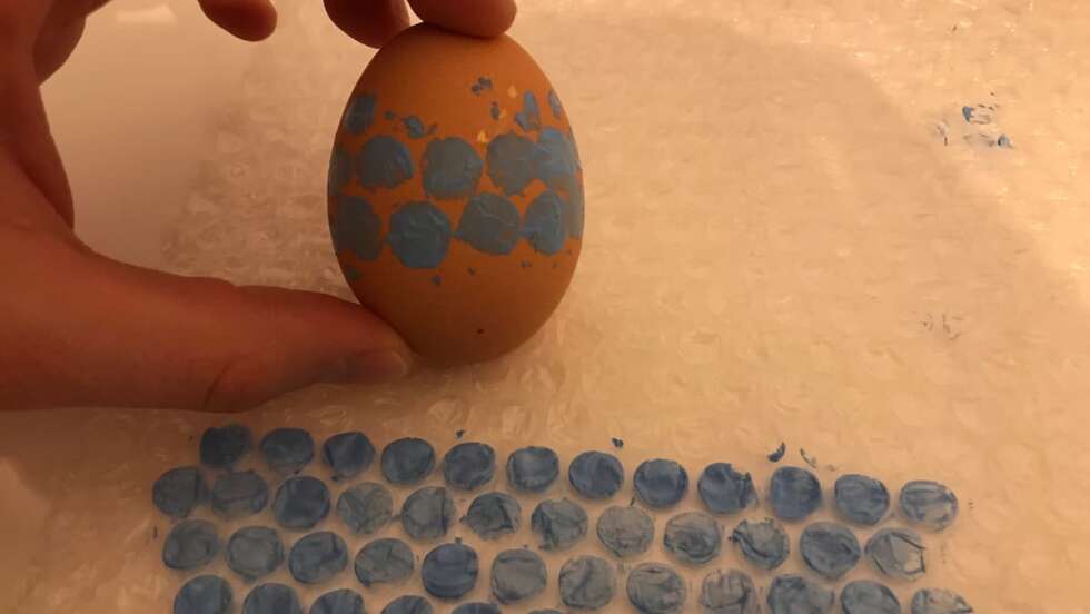 bemaltes Osterei und bemalte Luftpolsterfolie