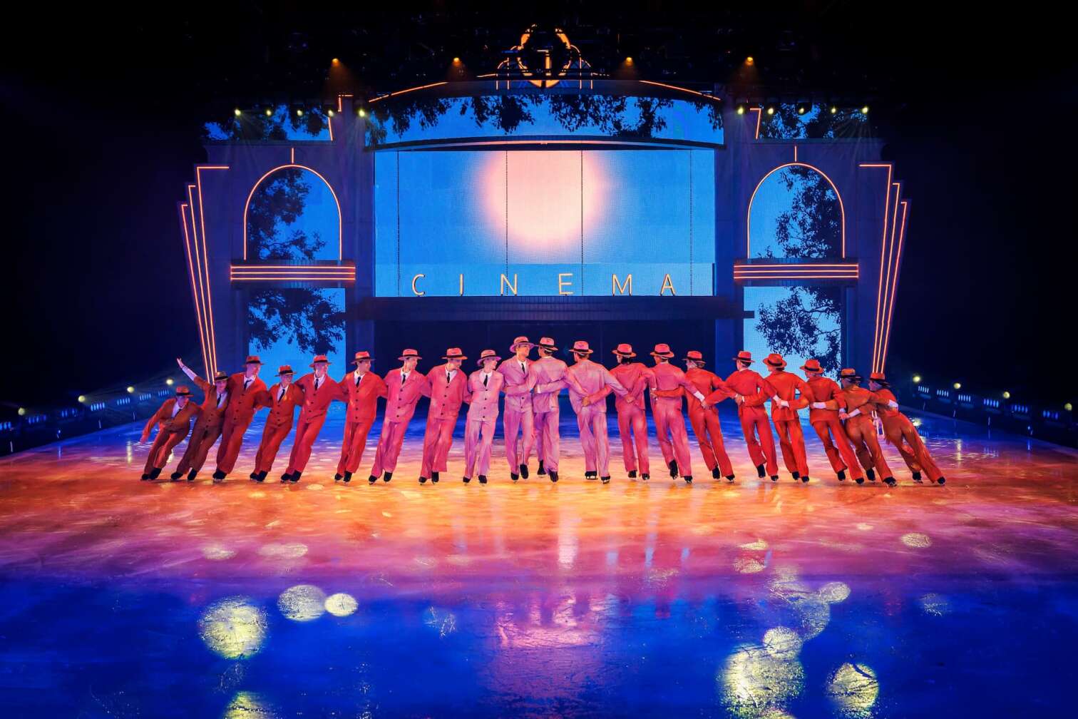 Foto des aktuellen Programms CINEMA OF DREAMS der Eiskunstlauf-Show HOLIDAY ON ICE - zu sehen sind Eiskunstläufer und Eiskunstläuferinnen in bunten Kostümen vor der Kulisse eines Kinos
