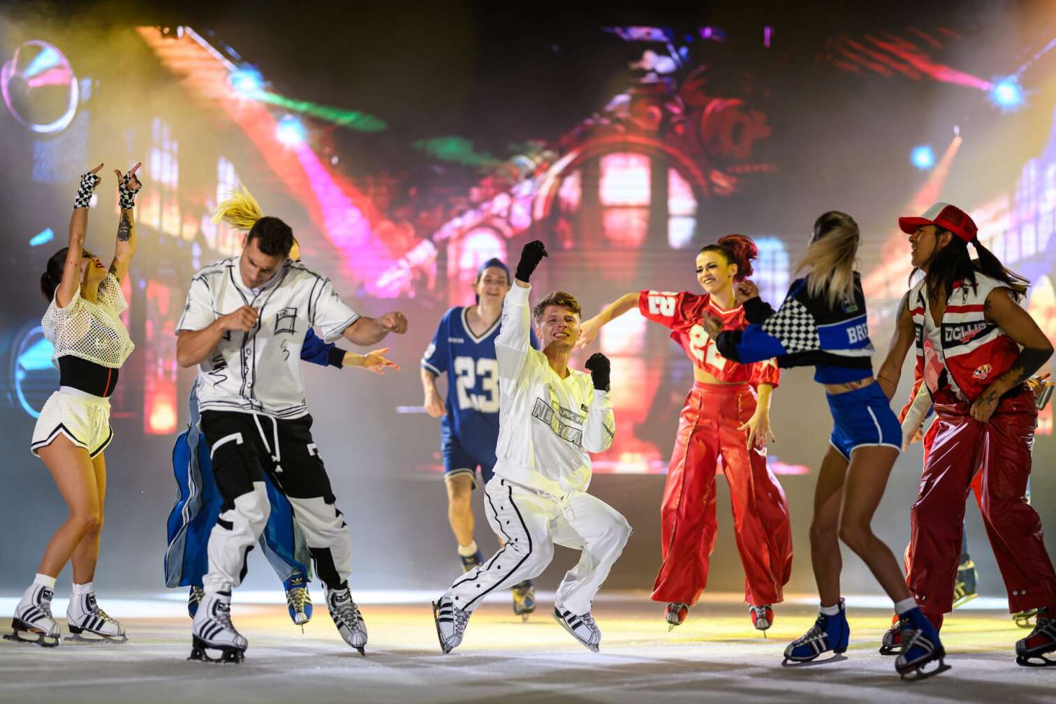 Foto des aktuellen Programms CINEMA OF DREAMS der Eiskunstlauf-Show HOLIDAY ON ICE - zu sehen sind Eiskunstläufer und Eiskunstläuferinnen in bunten Kostümen vor der Kulisse eines Kinos