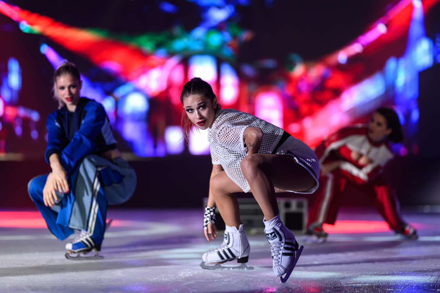 Foto des aktuellen Programms CINEMA OF DREAMS der Eiskunstlauf-Show HOLIDAY ON ICE - zu sehen sind Eiskunstläufer und Eiskunstläuferinnen in bunten Kostümen vor der Kulisse eines Kinos