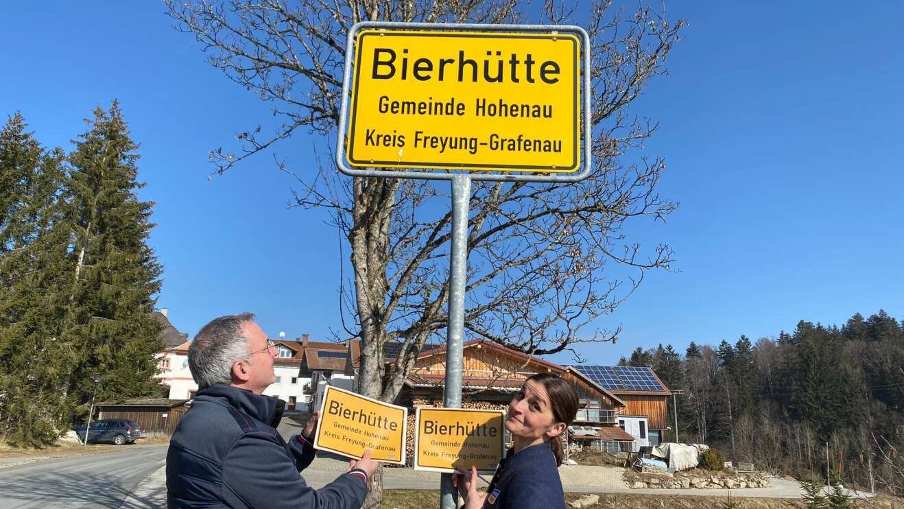 Heimatministerin und Bewohner mit Schild in der Hand