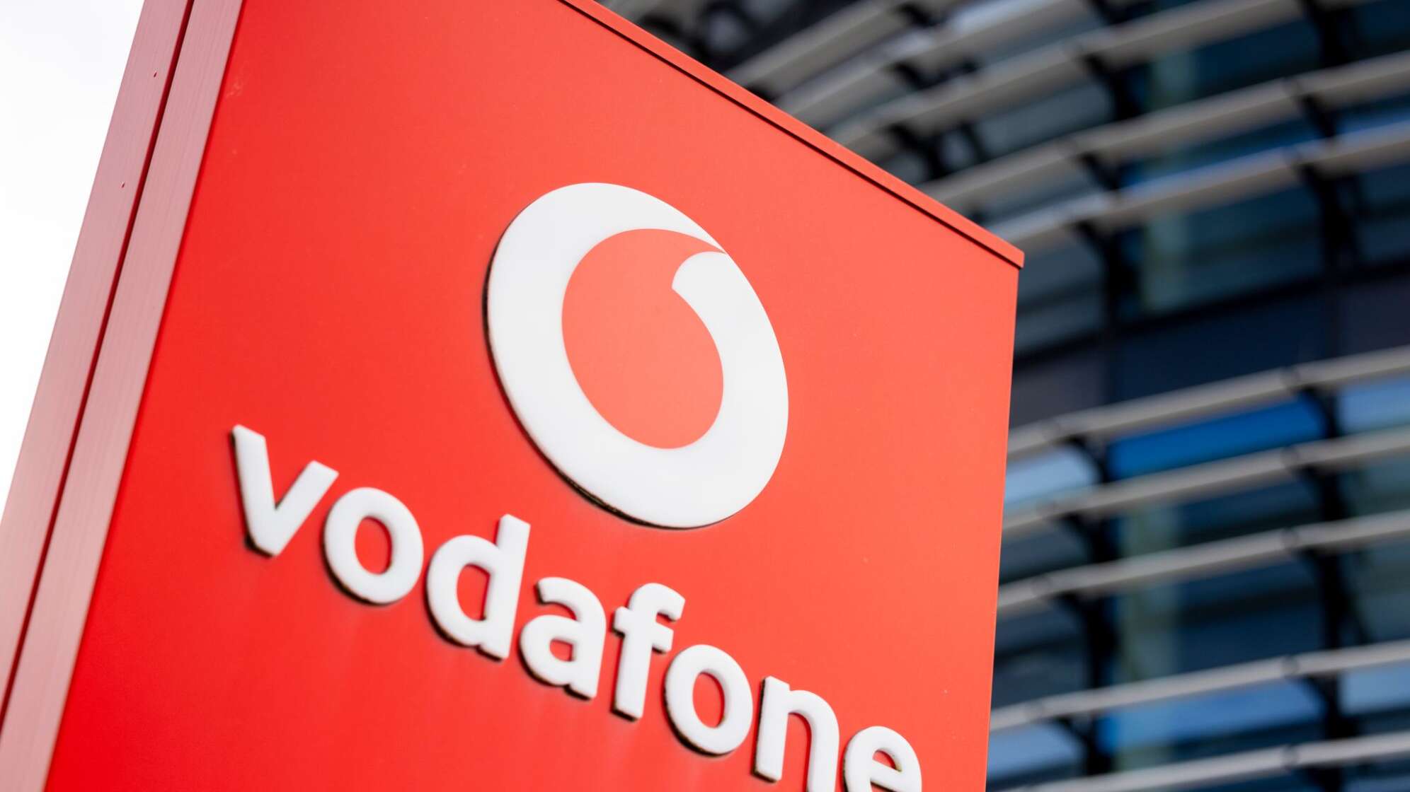 Firmenschild mit dem Logo von Vodafone steht vor Konzernzentrale