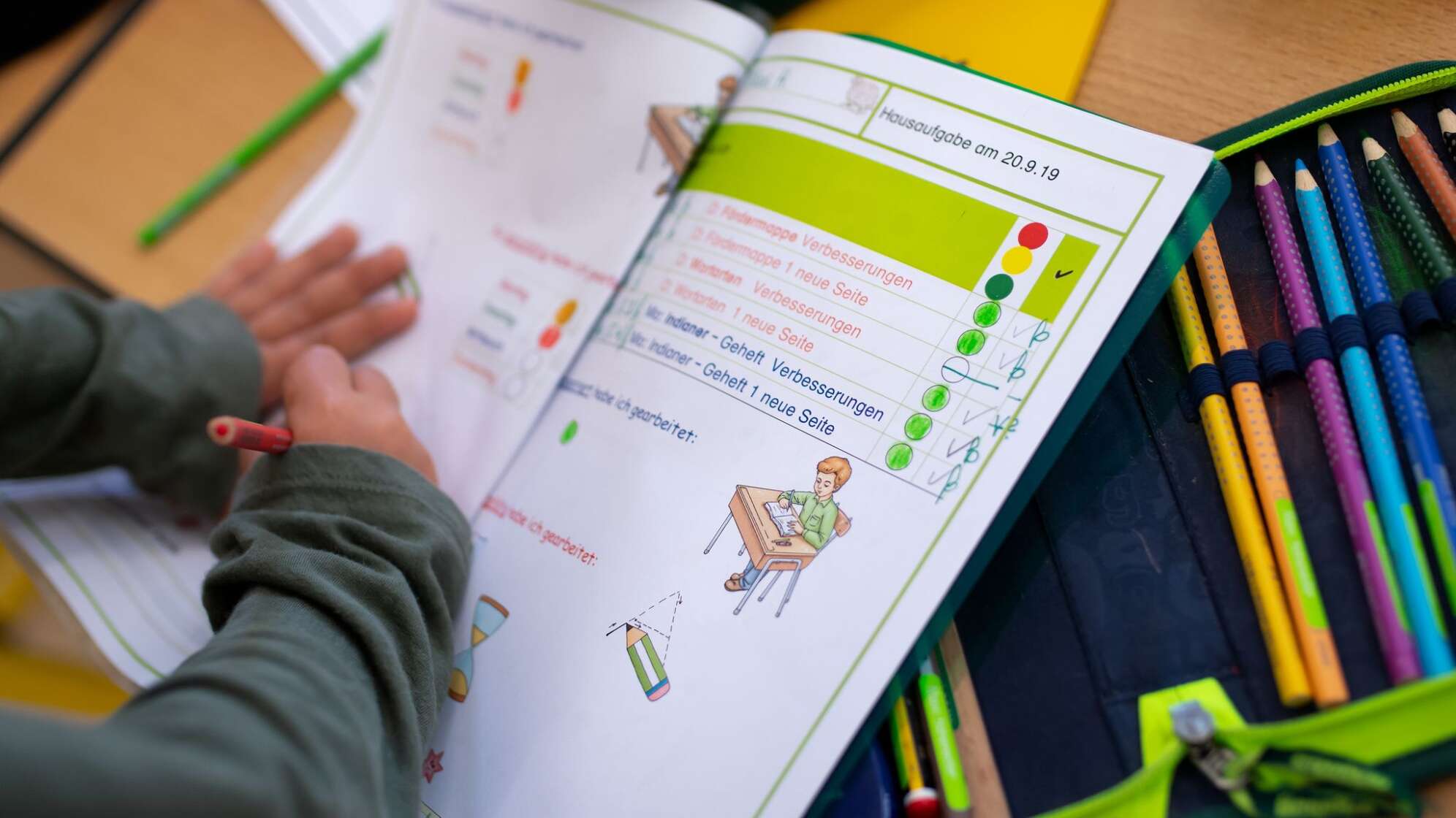 Kind arbeitet in Schulheft