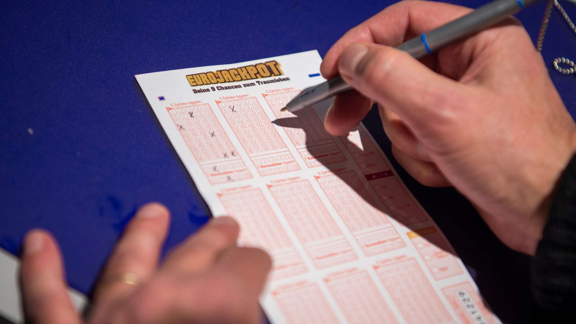 Mann kreuzt auf Lottoschein des Spiels «Eurojackpot» Zahlen an