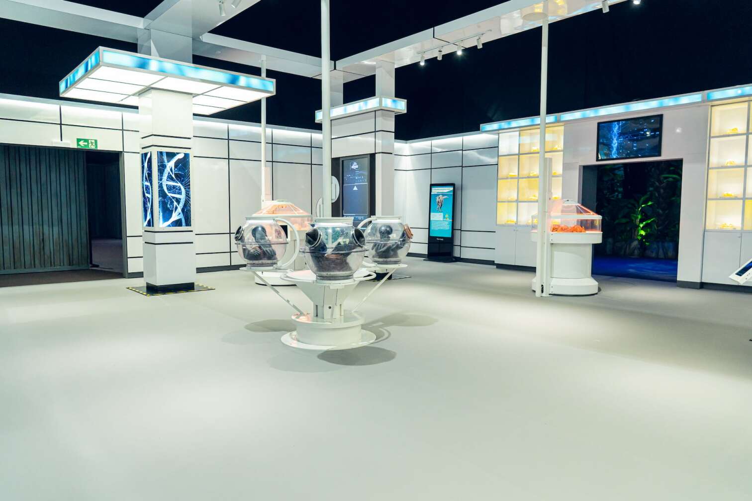Modern gestalteter Laborraum der Jurassic World Ausstellung mit beleuchteten Inkubatoren, DNA-Darstellungen und Informationsbildschirmen