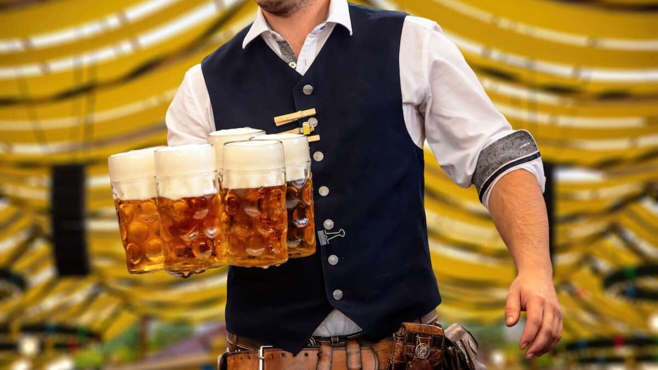 Kellner in Tracht mit Maßkrügen
