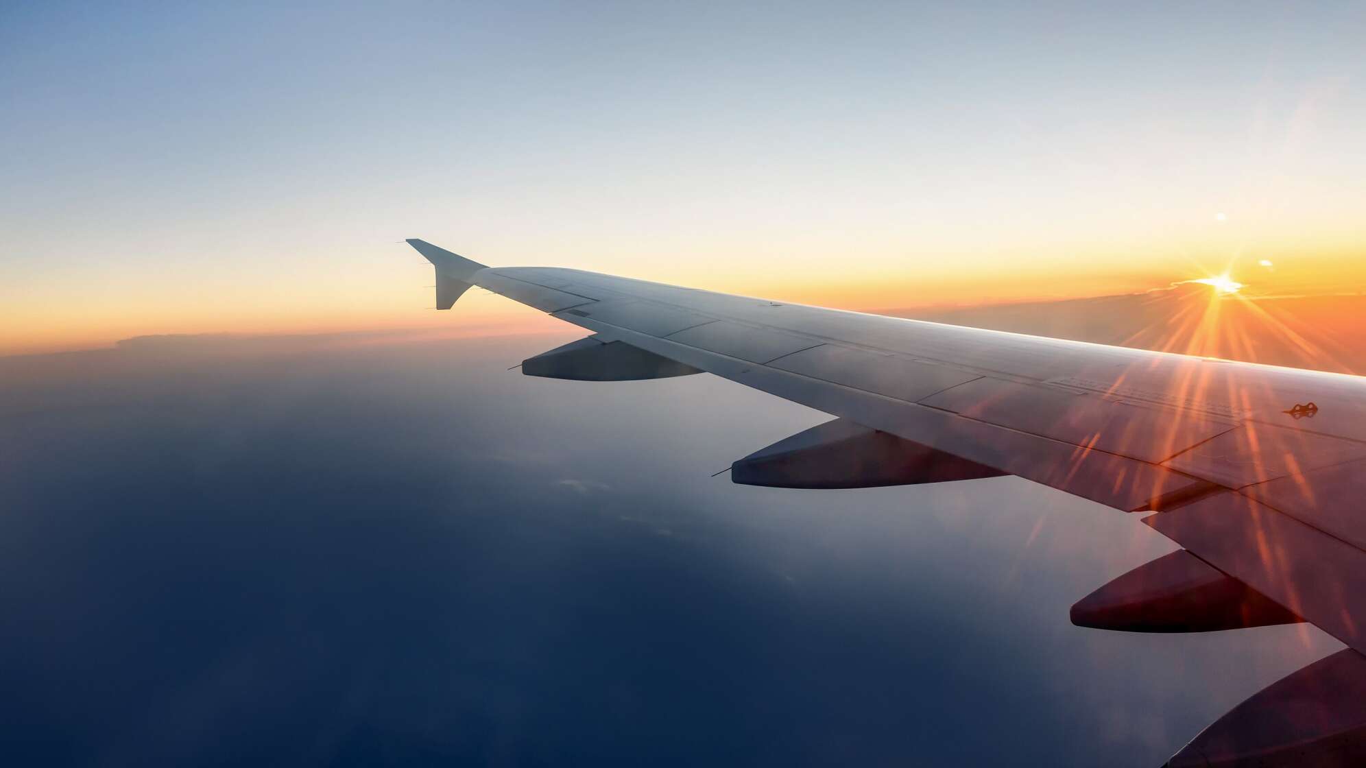 Flügel im Flugzeug mit Sonnenuntergang