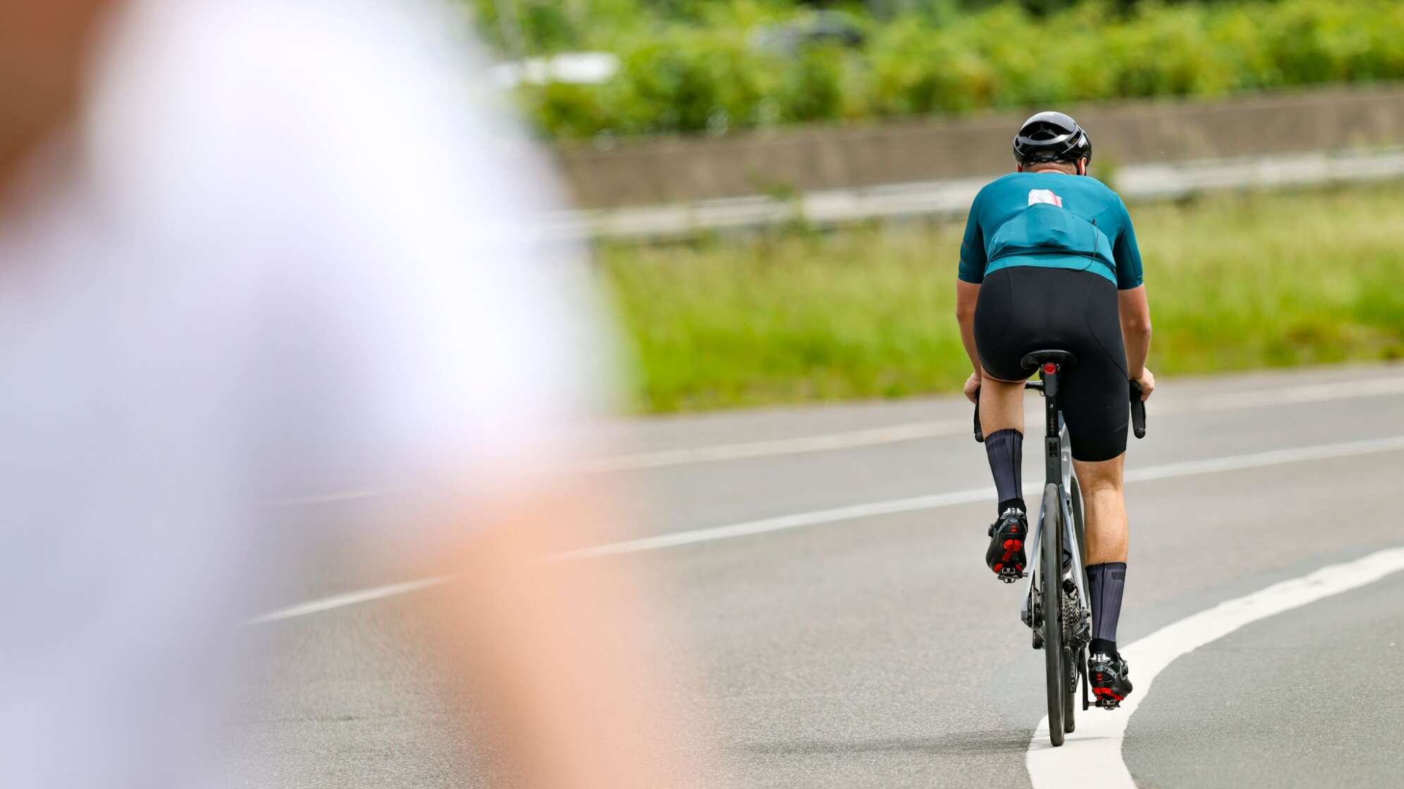 Ein Radfahrer fährt in der Sonne auf seinem Rennrad