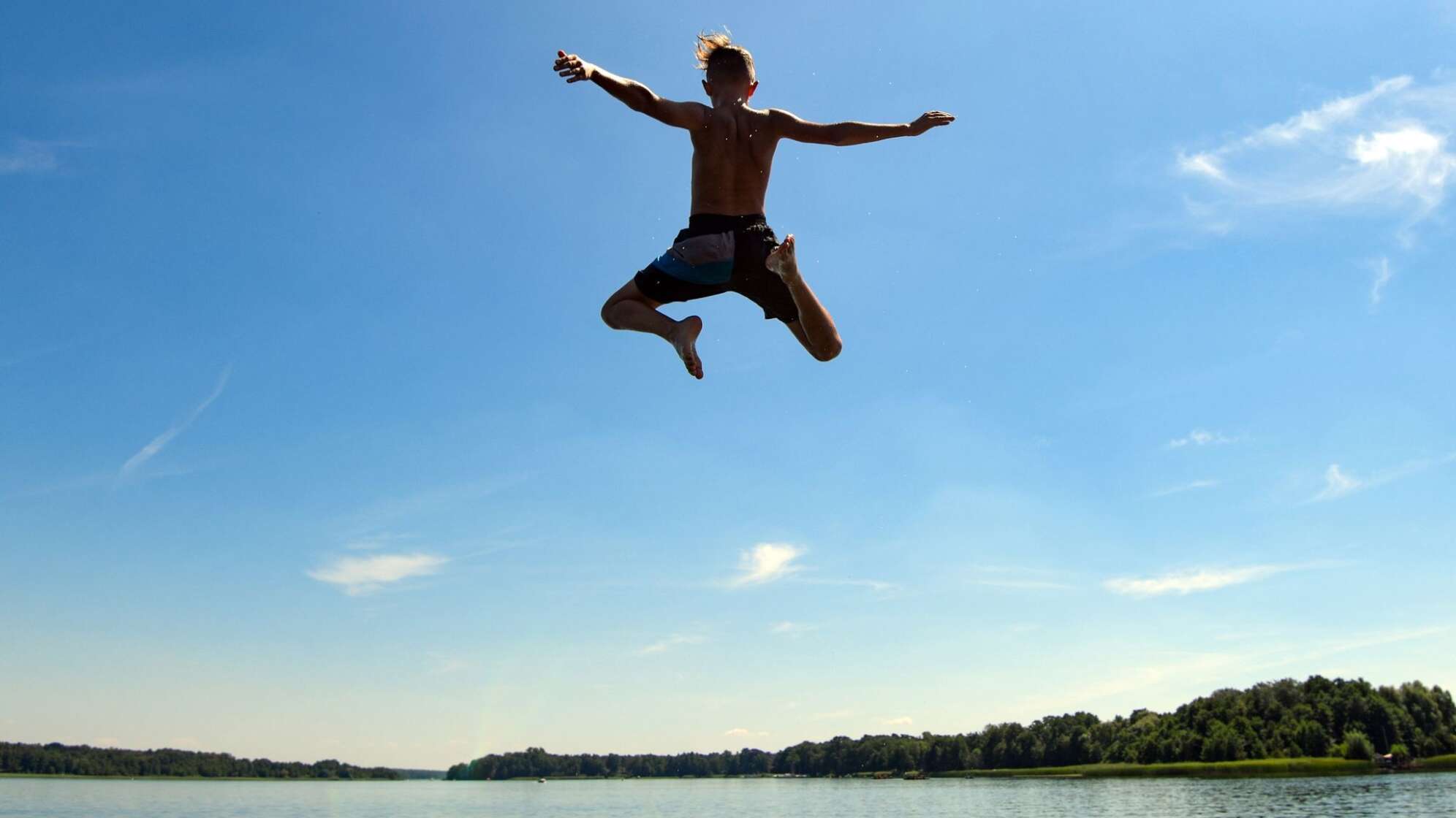 Ein Mann springt in einen See