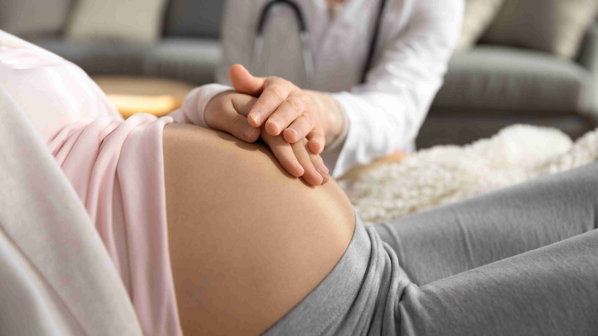 Frau hält Bauch einer Schwangeren