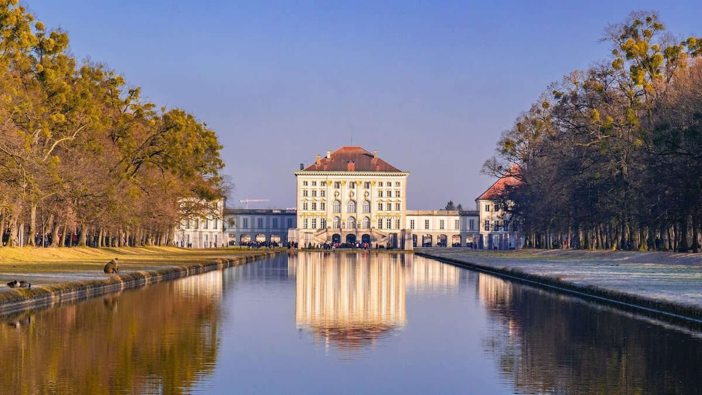 Das Schloss Nymphenburg spiegelt sich im Wasser