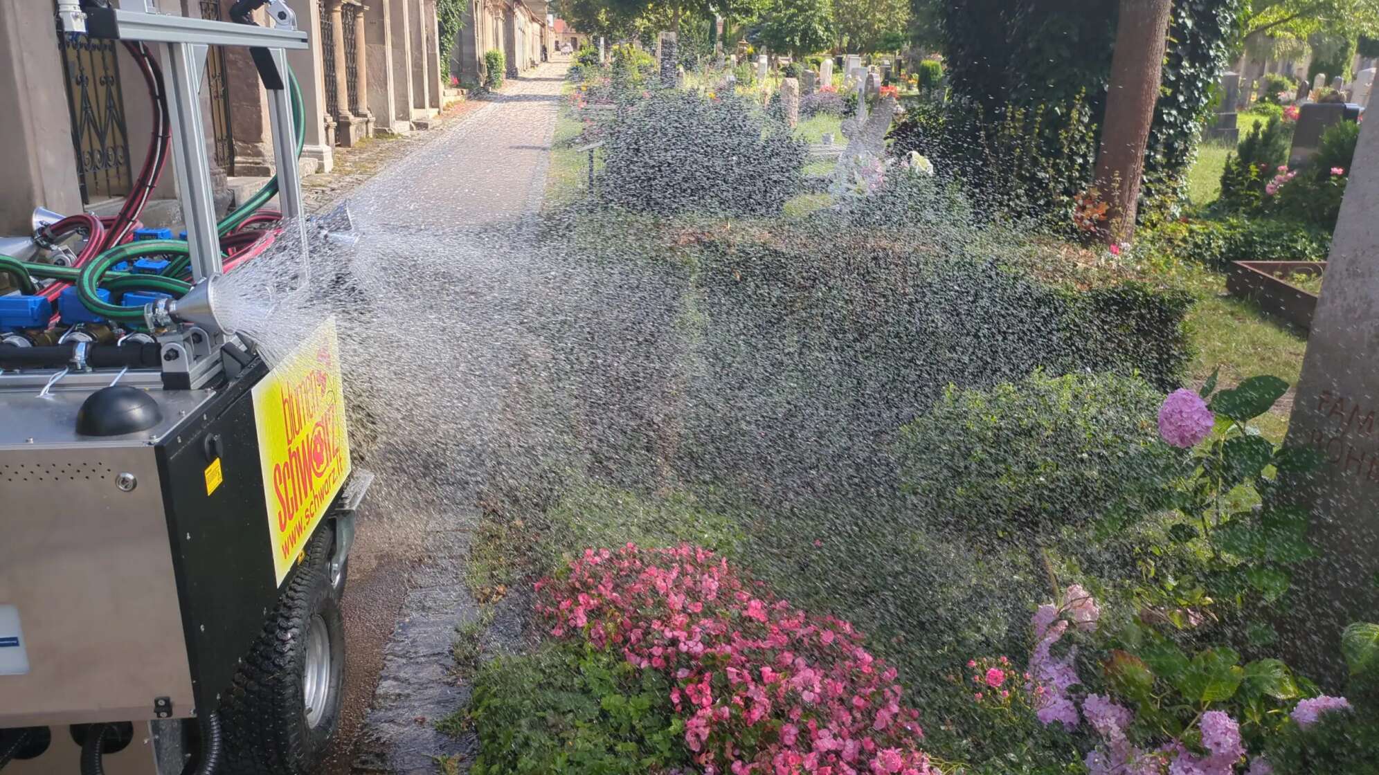 Ein Gießroboter, der ein Grab auf einem Friedhof gießt