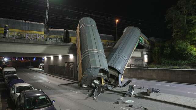 Zwei Güterzug-Waggons stürzen in München von Brücke