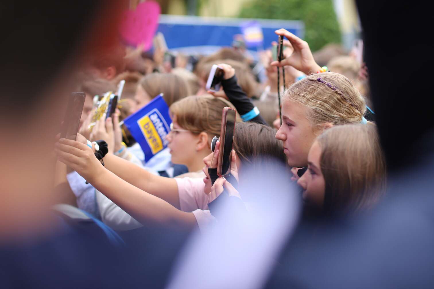 Popstar LOI am 23.07.2026 live auf der Bühne beim zweiten ANTENNE BAYERN Schulhof-Gig 2026 auf dem Pausenhof der Staatlichen Realschule in Neustadt bei Coburg in Oberfranken - Foto vom Konzert mit fröhlichen Schülern, hochgehaltenen Smartphones und Plakaten