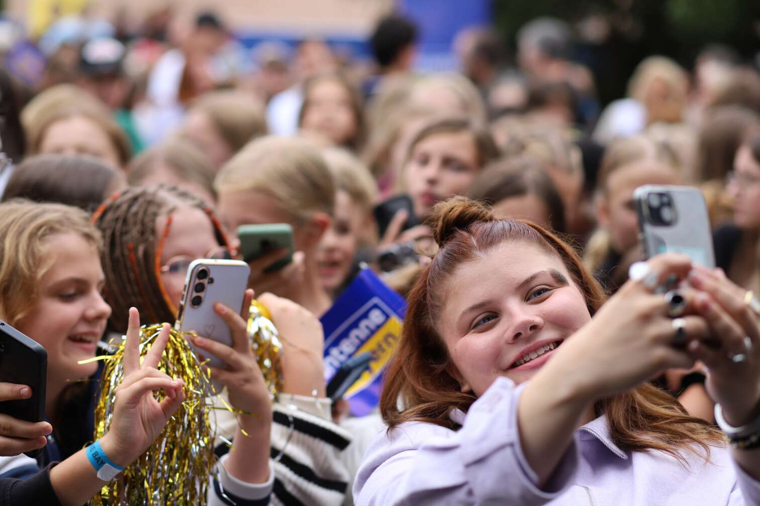 Popstar LOI am 23.07.2026 live auf der Bühne beim zweiten ANTENNE BAYERN Schulhof-Gig 2026 auf dem Pausenhof der Staatlichen Realschule in Neustadt bei Coburg in Oberfranken - Foto vom Konzert mit fröhlichen Schülern, hochgehaltenen Smartphones und Plakaten