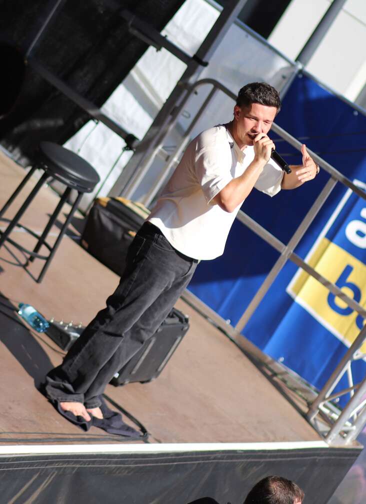 Popstar Nico Santos am 30.07.2026 live auf der Bühne beim dritten ANTENNE BAYERN Schulhof-Gig 2026 auf dem Pausenhof der Georg Hipp Realschule Pfaffenhofen - Foto vom Konzert mit fröhlichen Schülern, hochgehaltenen Smartphones und Plakaten
