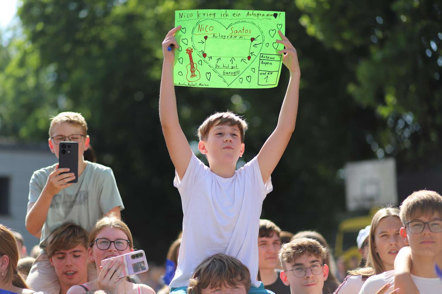 Popstar Nico Santos am 30.07.2026 live auf der Bühne beim dritten ANTENNE BAYERN Schulhof-Gig 2026 auf dem Pausenhof der Georg Hipp Realschule Pfaffenhofen - Foto vom Konzert mit fröhlichen Schülern, hochgehaltenen Smartphones und Plakaten
