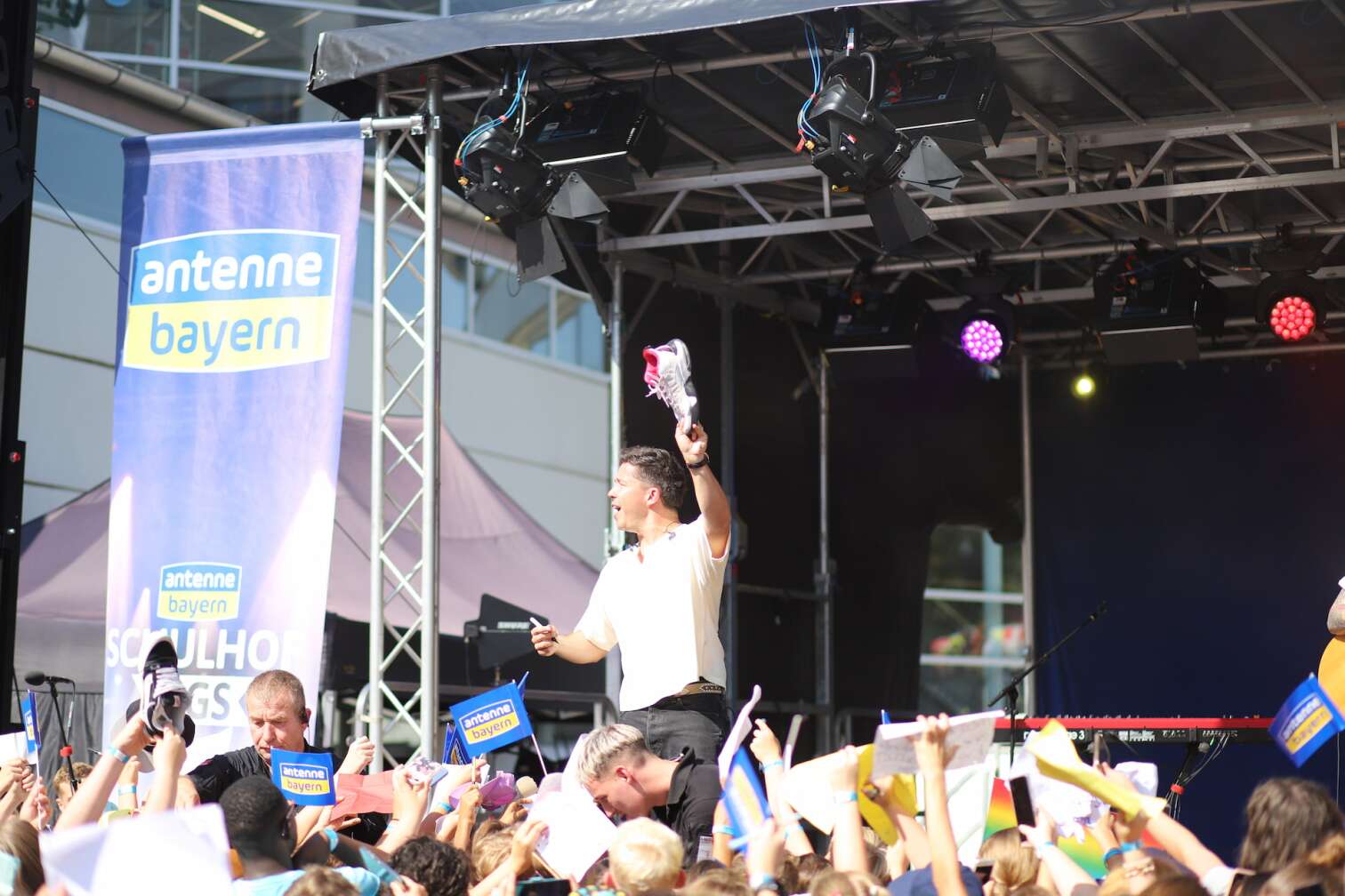 Popstar Nico Santos am 30.07.2026 live auf der Bühne beim dritten ANTENNE BAYERN Schulhof-Gig 2026 auf dem Pausenhof der Georg Hipp Realschule Pfaffenhofen - Foto vom Konzert mit fröhlichen Schülern, hochgehaltenen Smartphones und Plakaten
