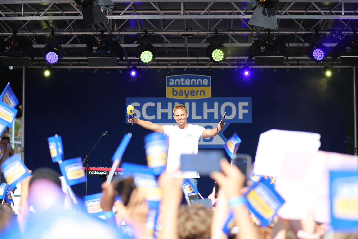 Popstar Nico Santos am 30.07.2026 live auf der Bühne beim dritten ANTENNE BAYERN Schulhof-Gig 2026 auf dem Pausenhof der Georg Hipp Realschule Pfaffenhofen - Foto vom Konzert mit fröhlichen Schülern, hochgehaltenen Smartphones und Plakaten
