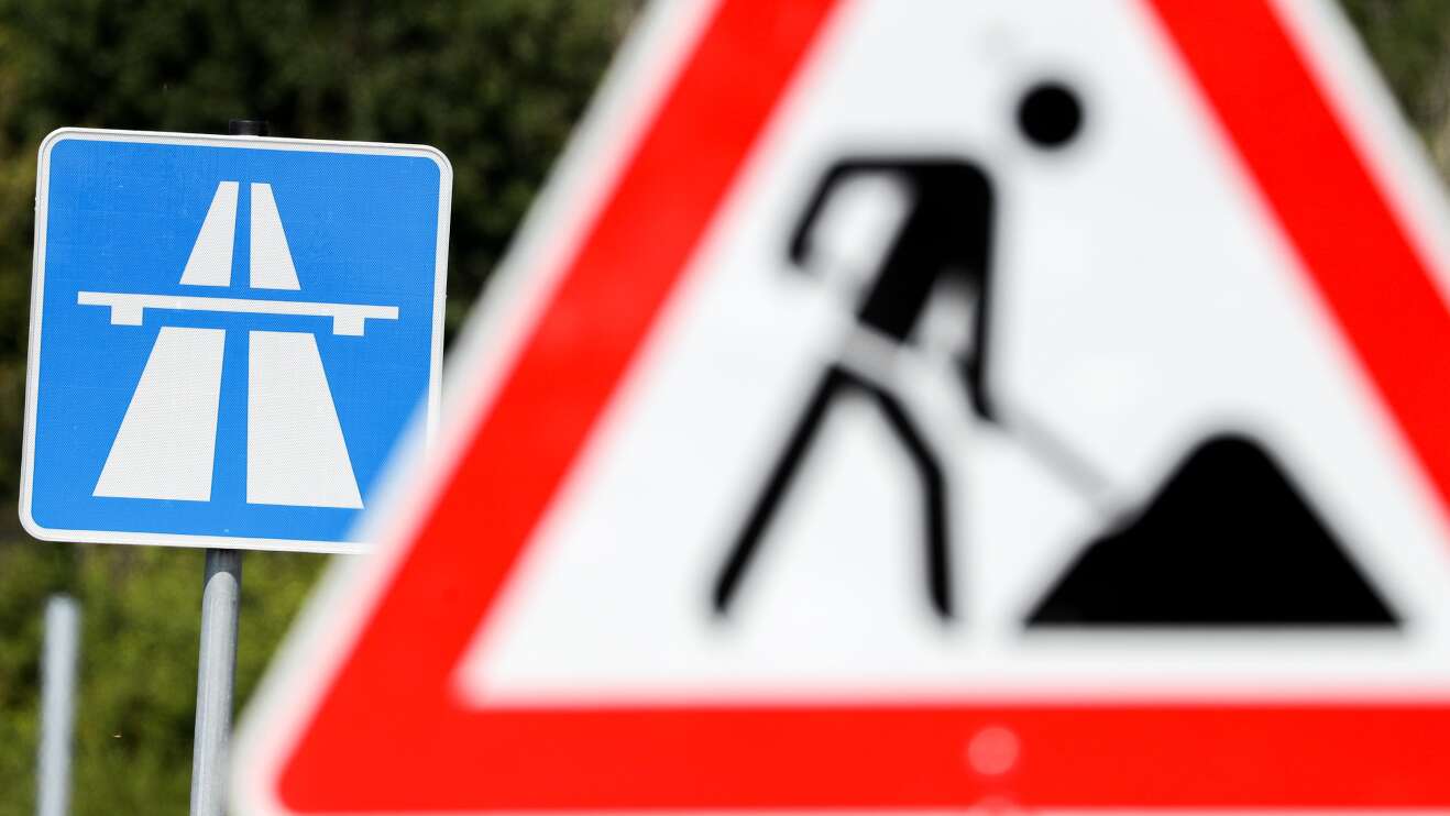 Baustellenschild vor einem Autobahnschild