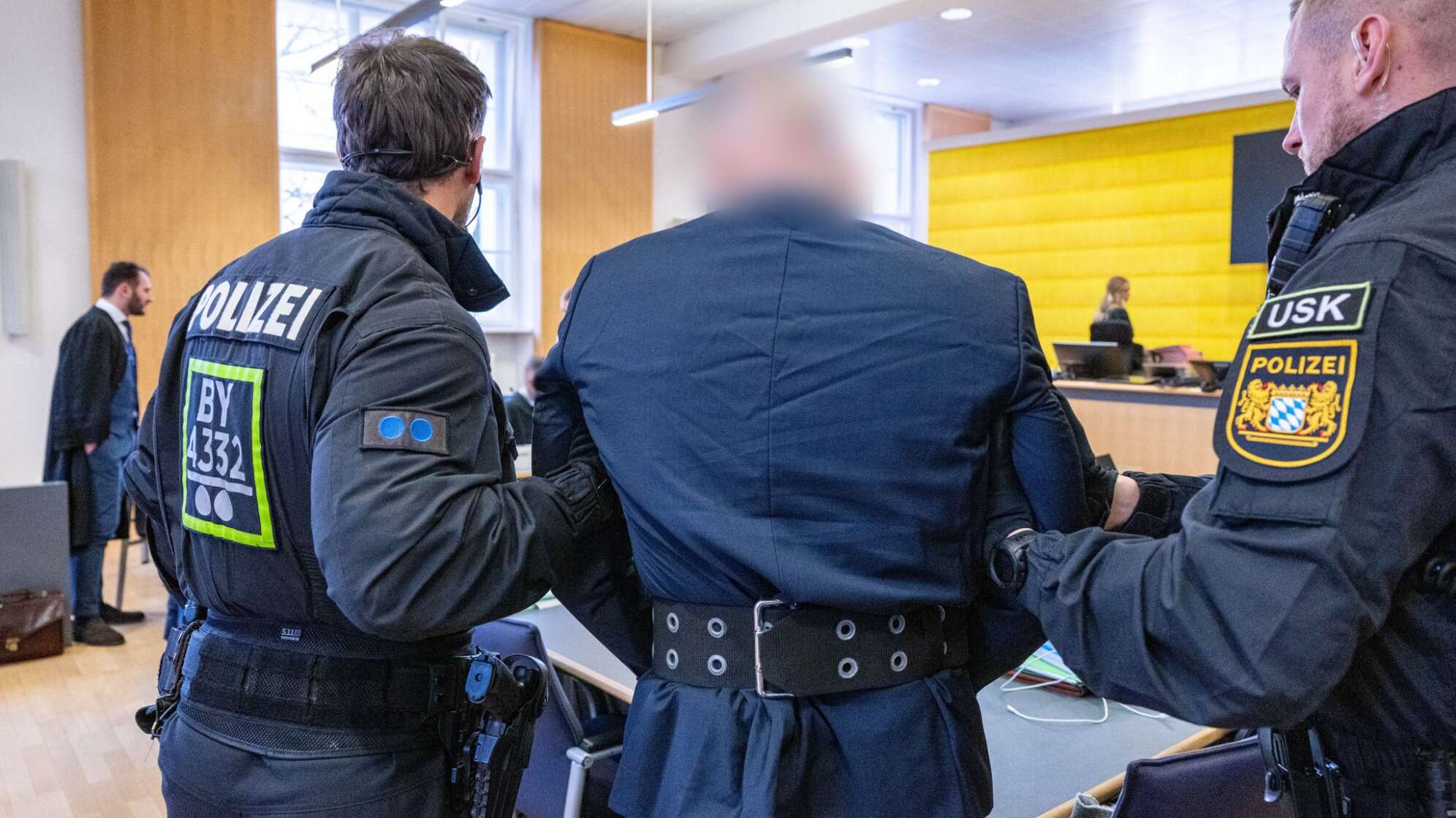 Polizisten bringen Angeklagten ins Gericht
