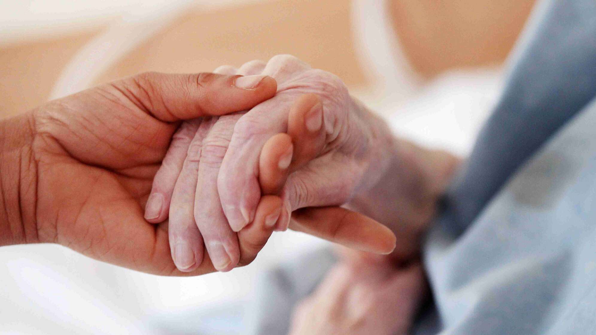 Person hält Hand einer alten Person