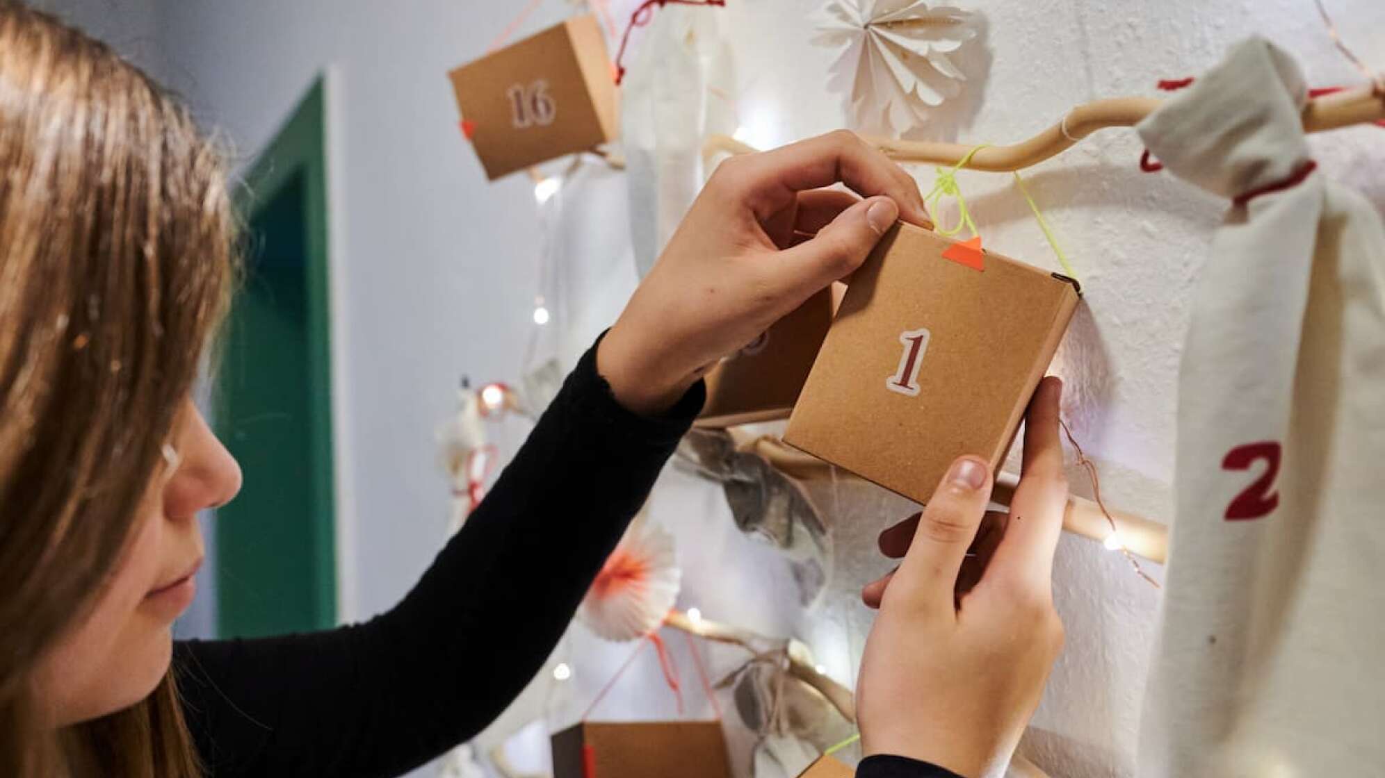 Mädchen hängt einen Adventskalender auf