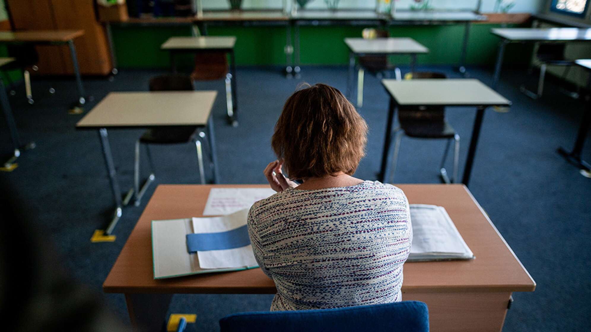 Ein Lehrerin sitzt in einem Klassenraum