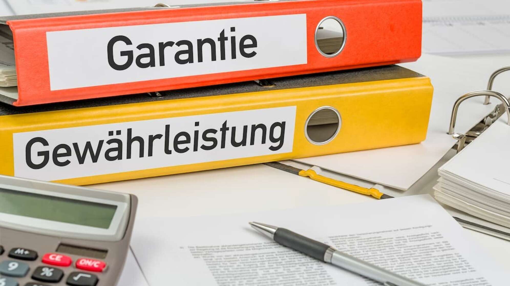 Zwei Ordner orange und gelb mit den Aufschriften Garantie und Gewährleistung