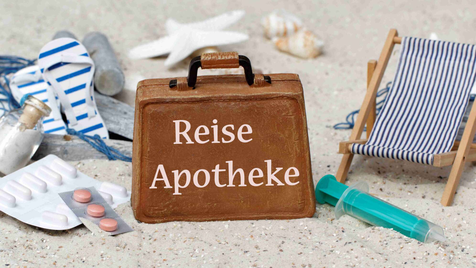 Reise-Apotheke Koffer im Sand