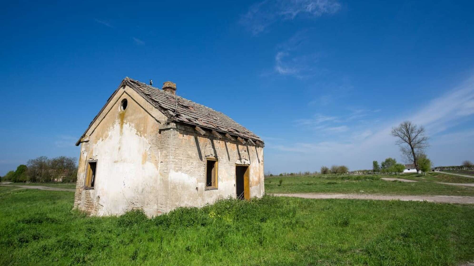 Heruntergekommenes Haus in schöner grüner Landschaft