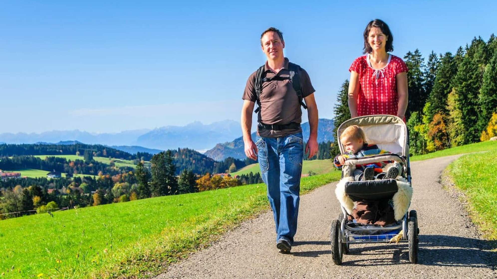 Familie mit Kinderwagen geht wandern