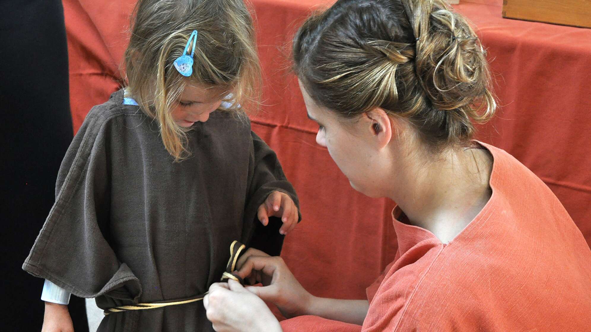 Frau bindet Schleife von Kind