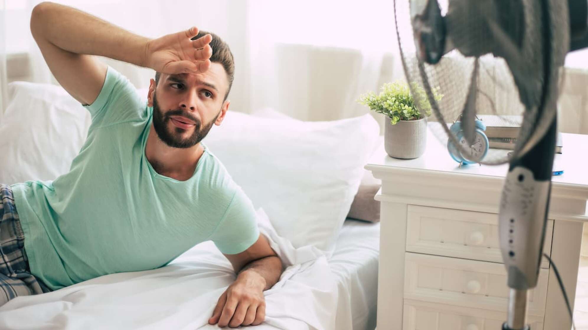 Mann im Bett mit Ventilator