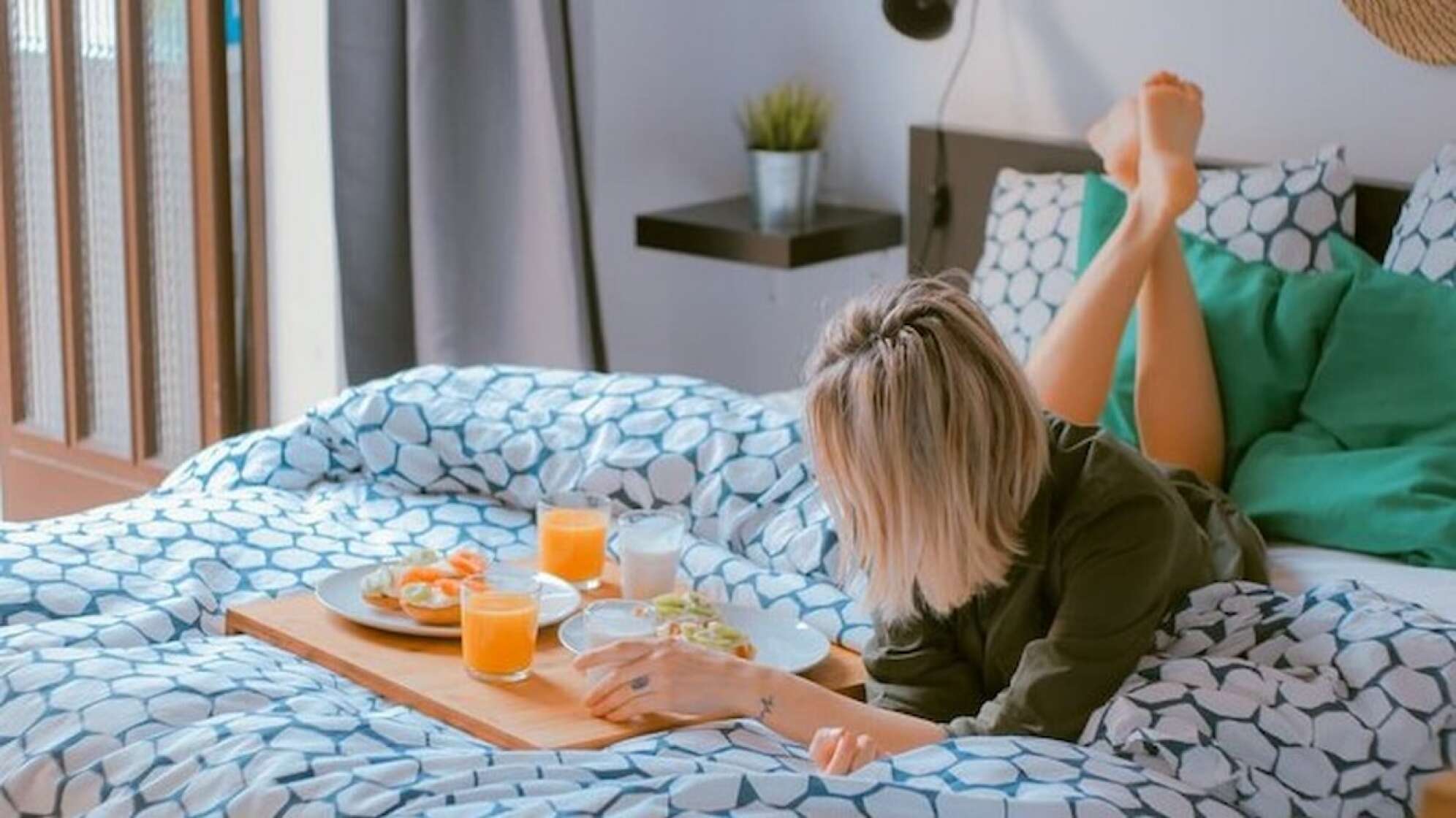 Frau liegt mit Essen im Bett