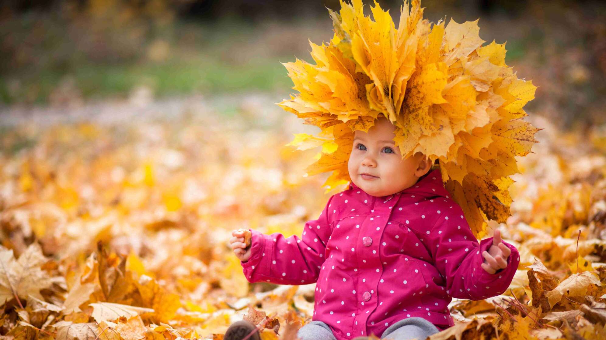 Kleines Kind mit Blättern auf dem Kopf