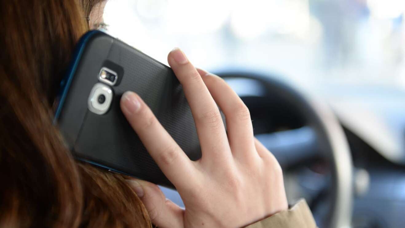 Eine Frau mit Handy am Ohr.
