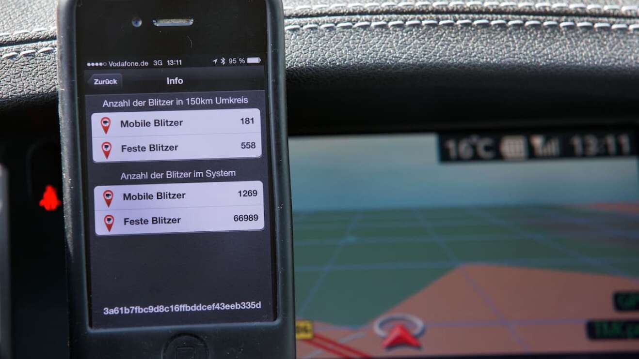 Ein Handy mit installierter Blitzer-App im Auto.