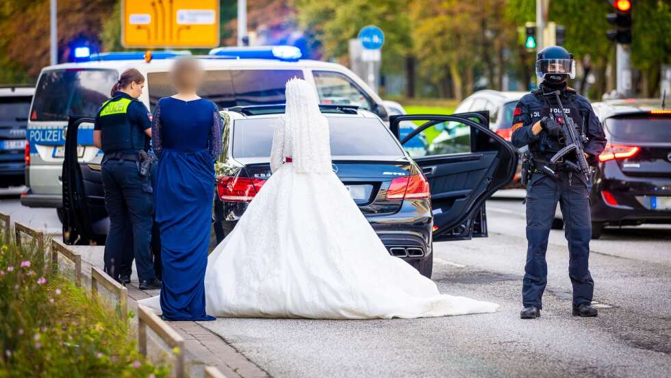Schwerbewaffnete Polizisten durchsuchen Hochzeitskorso