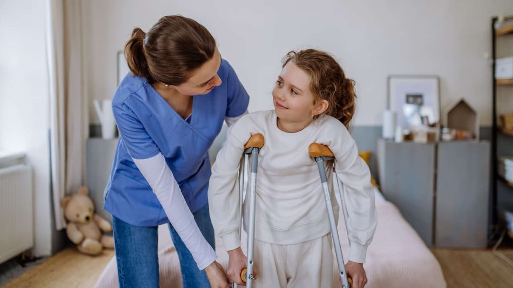 Kinderkrankenschwester mit Kind in Krücken