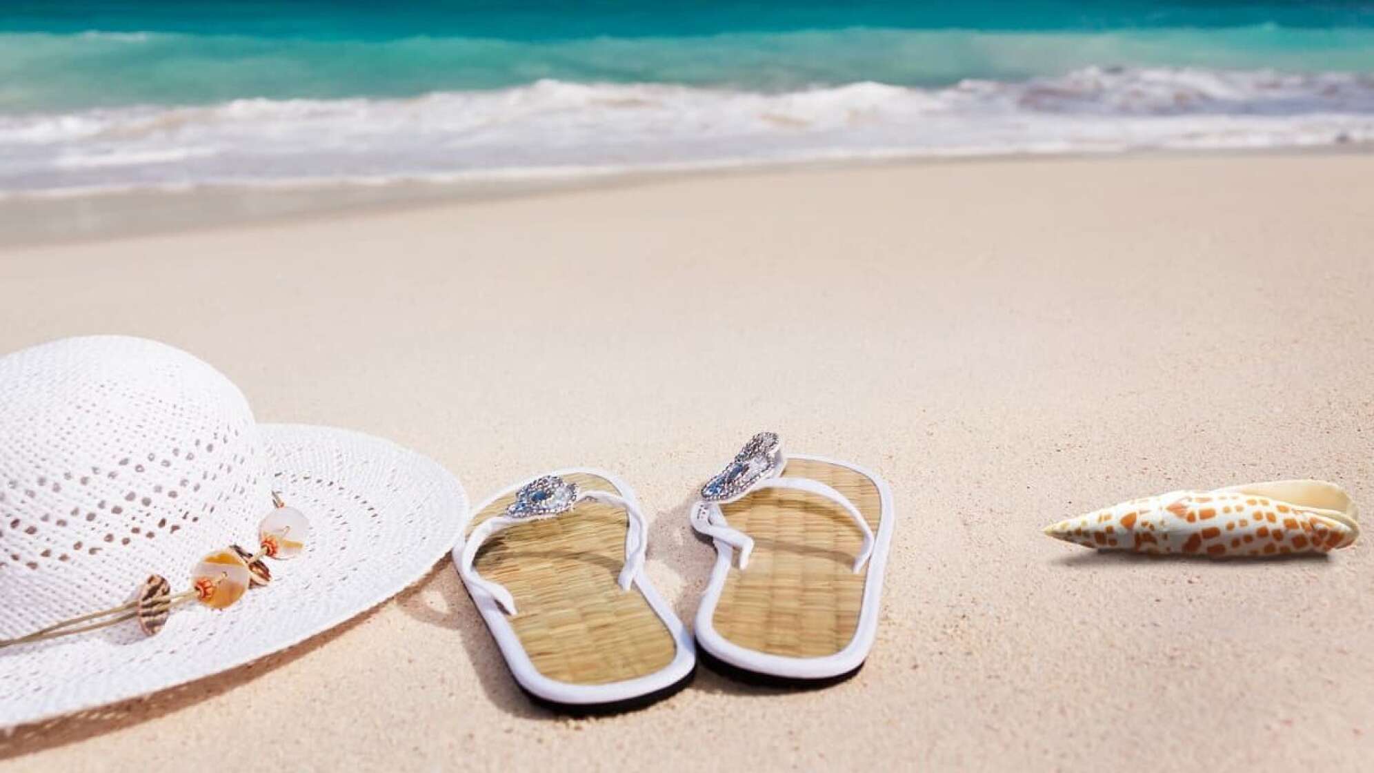 Strand mit Flip Flops und Sonnenhut