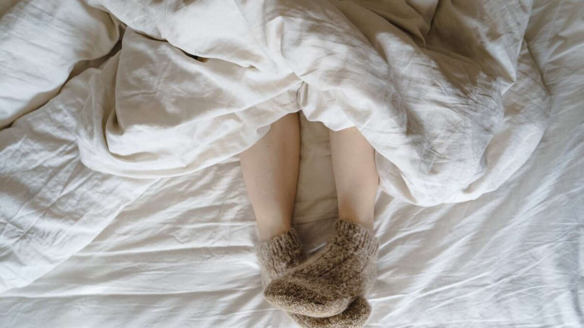 Zudecke und Kuschelsocken an den Füßen